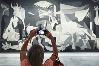Una mujer fotografía el 'Guernica' en el Museo Reina Sofía de Madrid.