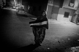 Mahfouda Lafkir, que es una activista de Laayoune, despliega una bandera de la RASD (República Árabe Saharaui Democrática) en una calle cercana a una comisaría de policía para sacar imágenes en pro de la causa saharaui.