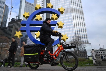Un ciclista pasa por delante del logotipo del euro situado delante de la sede del Banco Central Europeo en Frankfurt