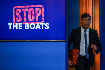 El primer ministro británico, Rishi Sunak, se dirige a una comparecencia de prensa con un fondo contra la llegada de buques con inmigrantes.