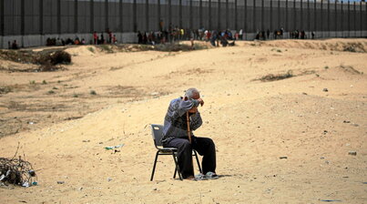 Un hombre, sentado en un campamento de desplazados de Rafah, junto a la frontera de Egipto.
