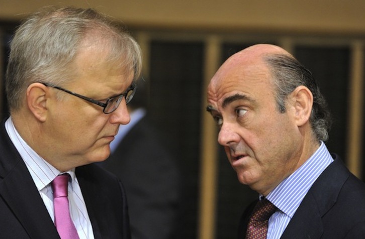 El responsable de Asuntos Económicos de la CE, Olli Rehn, charla con Luis de Guindos, ministro español de Economía. (Geoges GOBET/AFP PHOTO)