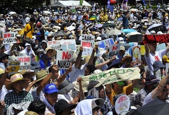 Dos jóvenes portan carteles contra la energía nuclear. (Yoshikazu TSUNO/AFP)