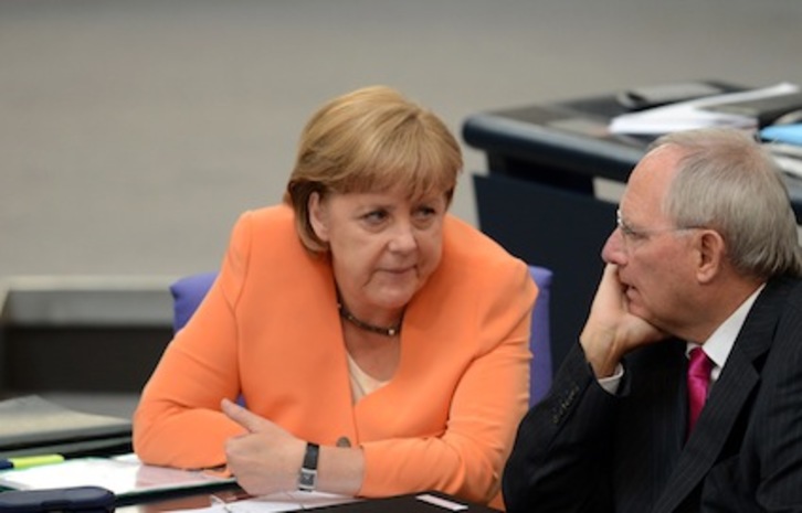 La canciller alemana, Angela Merkel, con el ministro de Finanzas, Wolfgang Schaeuble, durante la sesión extraordinaria en el Bundestag. (Johannes EISELE/AFP)