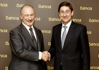 Rodrigo Rato estrecha la mano de José Ignacio Goirigolzarri, su sucesor en la presidencia de Bankia. (AFP)