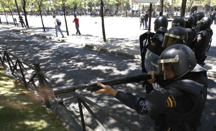Un policía español dispara una pelota de goma en el centro de Madrid contra la marcha negra de los mineros (Cesar MANSO/AFP PHOTO)