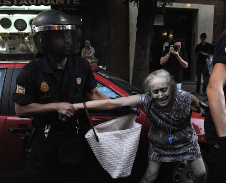 Un policía arresta a una mujer durante una manifestación en Madrid contra los últimos recortes del Gobierno. (Dominique FAGET/AFP PHOTO)