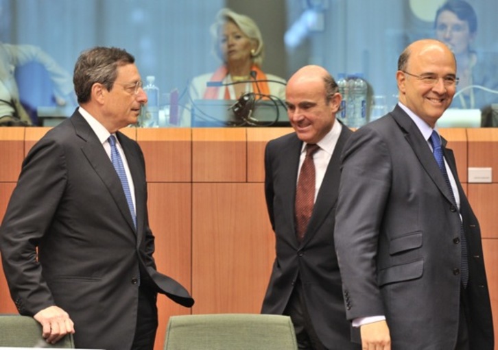 El presidente del BCE, Mario Draghi; el ministro español de Economía, Luis de Guindos, y su homólogo francés, Pierre Moscovici, durante la reunión del Eurogrupo en Bruselas.(Georges GOBET/AFP) 