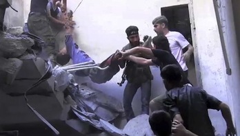 Imagen captada de un vídeo de AFP TV, donde varias personas intentan trasladar el cuerpo de un joven. (AFP)