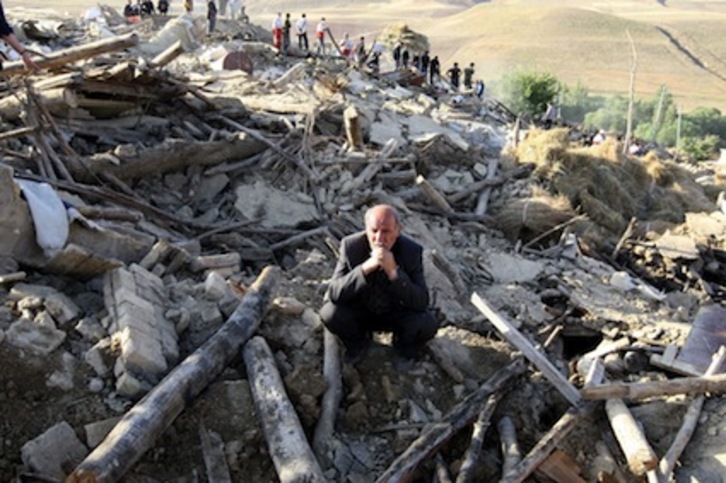 Un vecino de la localidad iraní de Baje-Baj, observa la devastadora situación que han dejado los terremotos. (Atta KENARE/AFP)