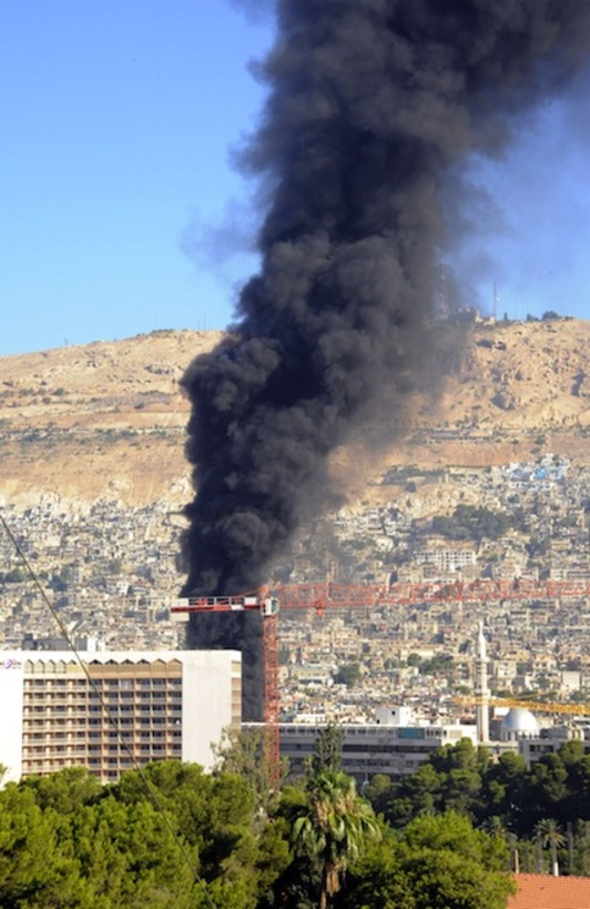 Columna de humo provocada por el estallido de una bomba en un hotel de Damasco. (AFP)