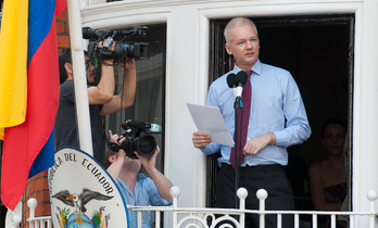 Assange ofrece la rueda de prensa vigilado por la Policía. (Carl COURT / AFP)