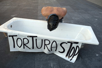 Una persona simula ser torturada con una bolsa en la cabeza y frente a una bañera. (Juan Carlos RUIZ/ARGAZKI PRESS)