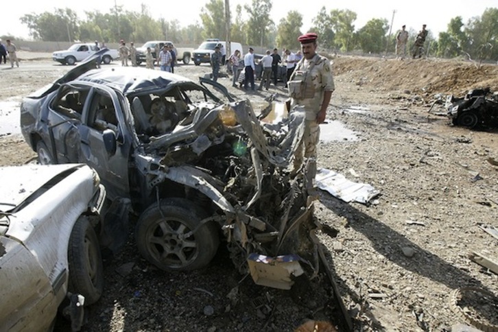 Un soldado iraquí observa un vehículo dañado a causa de la explosión registrada en la ciudad de Kirkuk.  (Marwan IBRAHIM/AFP PHOTO)