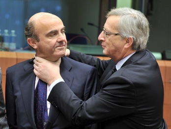 El ministro español de Economía es saludado por el presidente del Eurogrupo, Jean-Claude Juncker.  Georges GOBET / AFP PHOTO