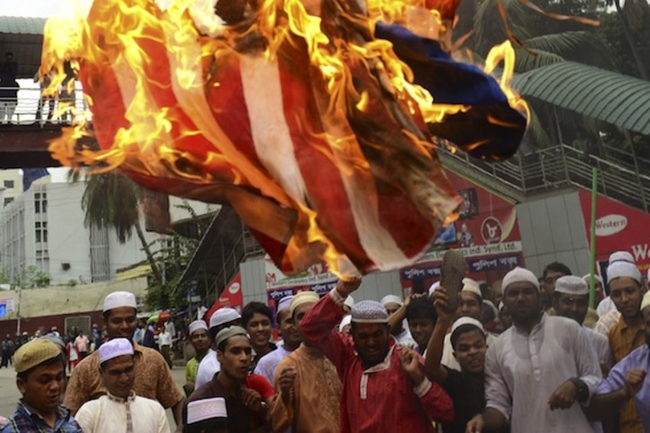 Manifestantes queman una bandera de EEUU en la ciudad de Dacca, en Bangladesh. (Munir UZ ZAMAN/AFP PHOTO)