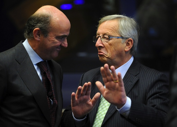 El ministro español de Economía, Luis de Guindos, charla con el presidente del Eurogrupo, Jean-Claude Juncker. John THYS / AFP PHOTO