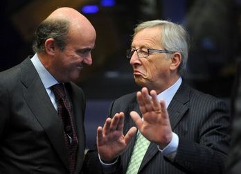 El ministro español de Economía, Luis de Guindos, charla con el presidente del Eurogrupo, Jean-Claude Juncker. (John THYS/AFP PHOTO) 