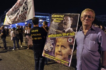 Un manifestante sostiene un cártel contra Angela Merkel durante una manifestación celebrada ayer en Atenas. (Louisa GOULIAMAKI/AFP PHOTO) 