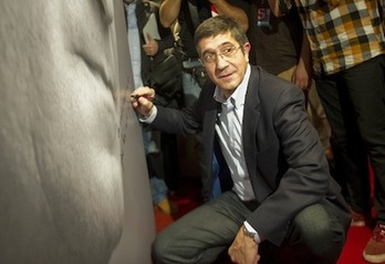 López escribe una dedicatoria en una imagen suya de gran tamaño. (Andoni CANELLADA/ARGAZKI PRESS)