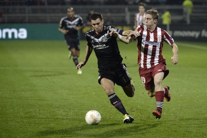 Muniain disputa un balón con Reveillere. (Fred DOUFOUR/AFP PHOTO)