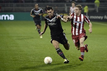 Muniain disputa un balón con Reveillere. (Fred DOUFOUR/AFP PHOTO)