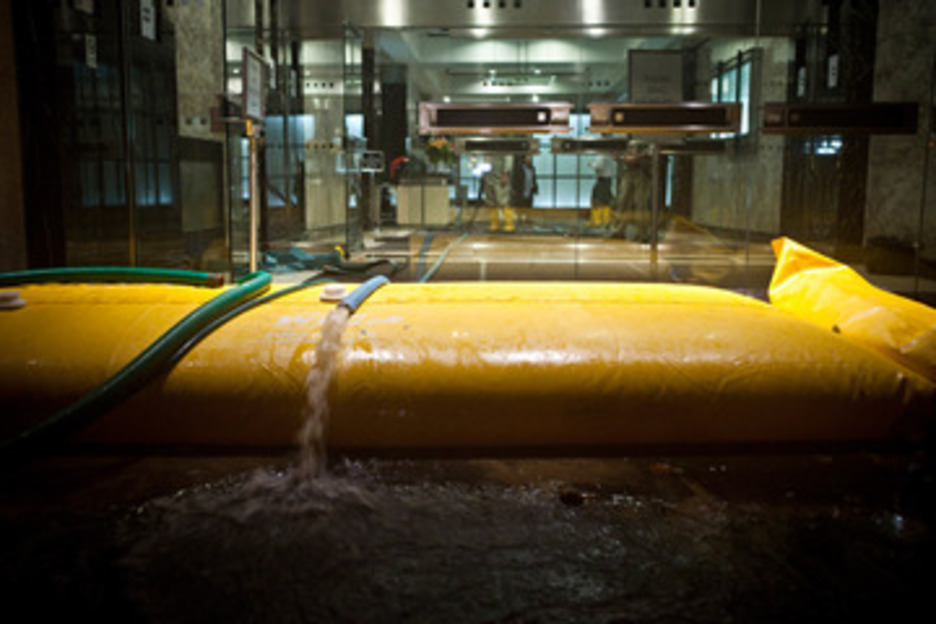 El agua ha llegado al distrito financiero. En la imagen, una bomba achica agua de unas oficinas. (Andrew BURTON/AFP)
