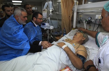 El líder de Hamas en Gaza, Ismail Haniya y el primer ministro egipcio, Hisham Qandil, visitan a una persona que ha resultado herida en un ataque aéreo israelí. (Mahmud HAMS/AFP)
