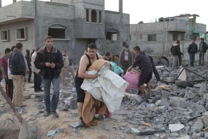 Varios palestinos recogen sus pertenencias de entre los escombros tras un ataque israelí. (Said KHATIB/AFP)