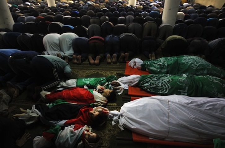 Palestinos rezan durante el funeral de la familia Al-Dallu, de la que nueve miembros murieron ayer en un ataque israelí. (Mahmud HAMS/AFP PHOTO)