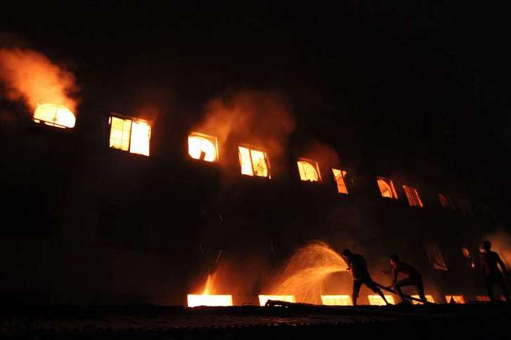 Los bomberos, durante las labores de extinción del fuego. (AFP PHOTO)