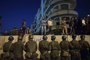 Opositores egipcios permanecen ante la sede presidencial de Mohamed Morsi al caer la noche. (Gianluigi GUERCIA/AFP)