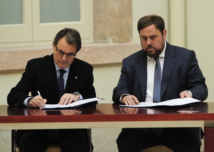 Artur Mas y Oriol Junqueras rubrican el acuerdo. (Josep LAGO/AFP)