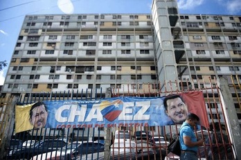 Imagen de una calle del barrio «23 de enero» con una pancarta de apoyo al presidente Chávez al fondo. (Raul ARBOLEDA/AFP)