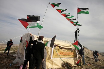 Activistas ondean banderas palestinas en el campamento de Bab al-Shams. (Abbas MOMANI/AFP) 