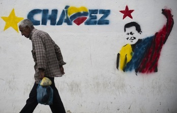 Un hombre pasa en Caracas ante un mural con la imagen de Hugo Chávez. (Raul ARBOLEDA/AFP PHOTO)