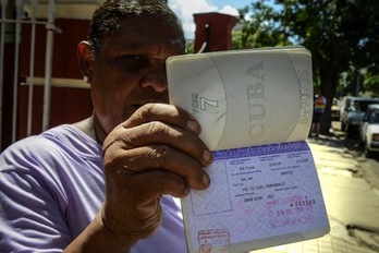 Una mujer cubana muestra su pasaporte en regla y con permiso para salir de la isla. (Adalberto ROQUE/AFP PHOTO)