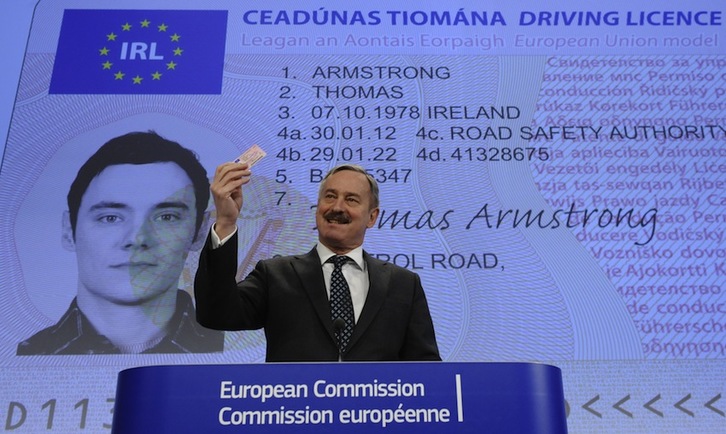 El responsable de Transportes europeo muestra el nuevo carné de conducir. (John THYS/AFP)