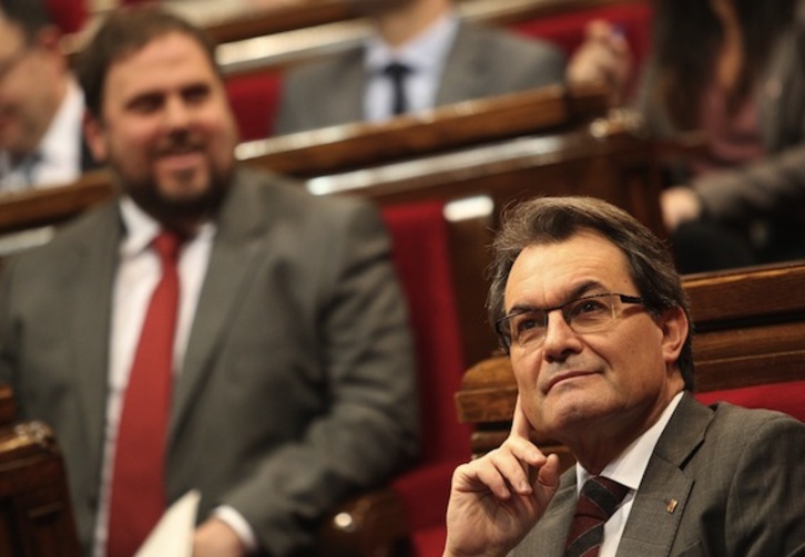 El president, Artur Mas, con el líder de ERC, Oriol Junqueras, detrás, en una sesión parlamentaria. (Quique GARCÍA/AFP)