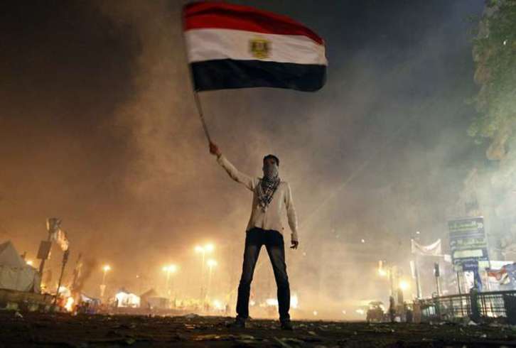 Un manifestante ondea la bandera de Egipto en medio de las protestas en la plaza Tahrir de El Cairo. (Mahmoud KHALED/AFP PHOTO)