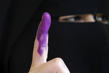 Una mujer niqabí muestra su dedo índice teñido, en unas elecciones egipcias. (Mohammed ABED/AFP)