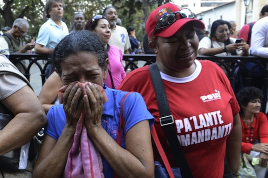 Dos mujeres lloran en Caracas la muerte del presidente venezolano. (Juan BARRETTO/AFP PHOTO)