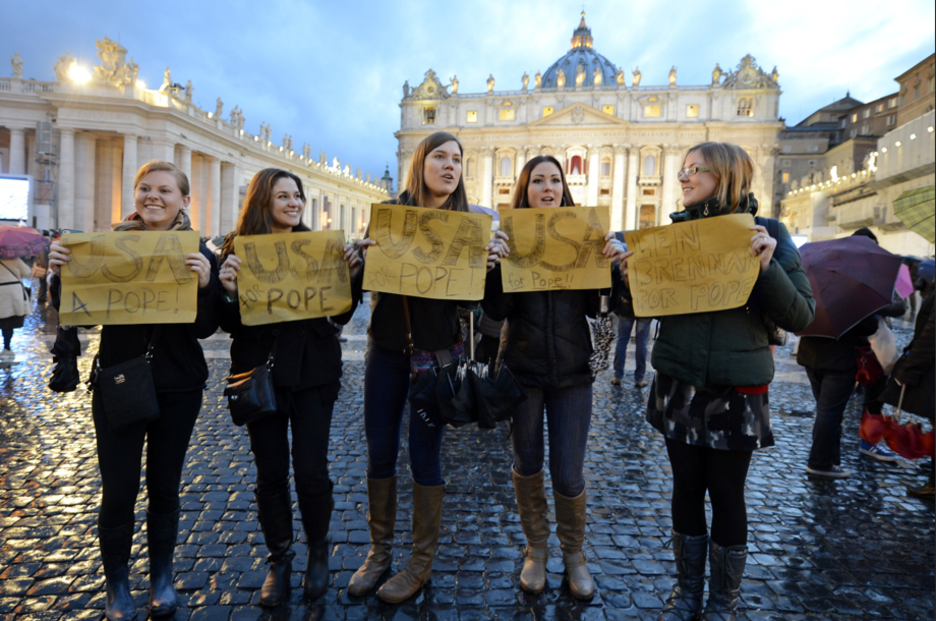 Católicos de todos los continentes se han dado cita en la Plaza San Pedro, cada uno tira para casa; estas jóvenes católicas piden un papa estadounidense. (Andreas SOLARO / AFP PHOTO)