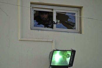 Un policía vigila desde una ventana del cuartel atacado. (Noorullah SHIRZADA/AFP PHOTO)