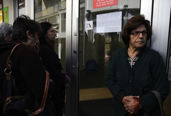 Ciudadanos chipriotas aguardan a las puertas de una sucursal bancaria. (Yiannis KOURTOGLOU/AFP PHOTO)
