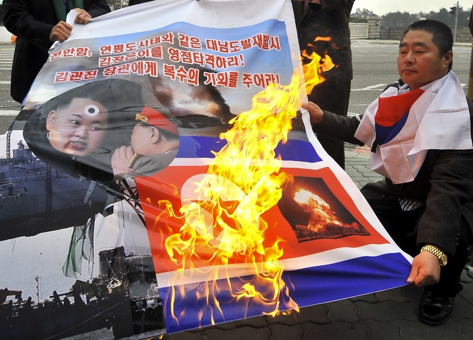 22 de marzo. Ciudadanos norcoreanos queman la bandera de Corea del Norte junto a la fotografía de su líder. (Jung YEON-JE / AFP PHOTO)
