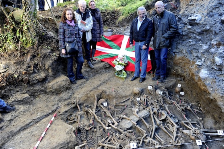 Autoridades locales, de Lakua y miembros de Aranzadi, junto a los restos exhumados en Etxaguen. (Juanan RUIZ/ARGAZKI PRESS)