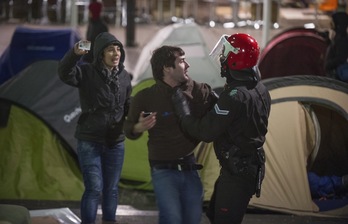 Un ertzaina zarandea a Lander Arbelaitz, ante la mirada de Maite Bidarte (Infozazpi), que muestra su carné de periodista. (Andoni CANELLADA/ARGAZKI PRESS)