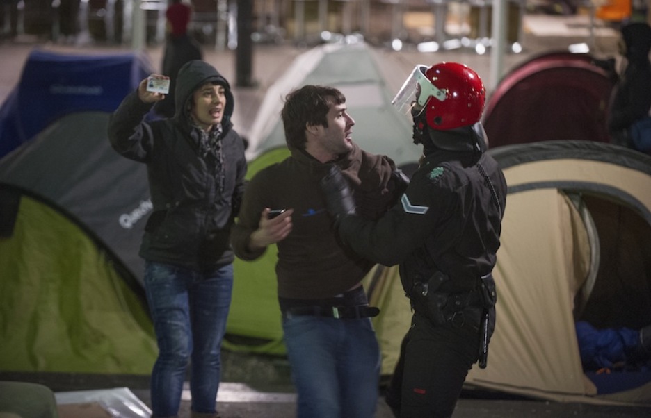 Un ertzaina zarandea a Lander Arbelaitz, ante la mirada de Maite Bidarte (Infozazpi), que muestra su carné de periodista. (Andoni CANELLADA/ARGAZKI PRESS)