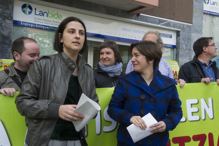 Las parlamentarias de EH Bildu Arri Zulaika y Leire Pinedo durante el acto frente a la sede de Lanbide. (Monika del VALLE/ARGAZKI PRESS)